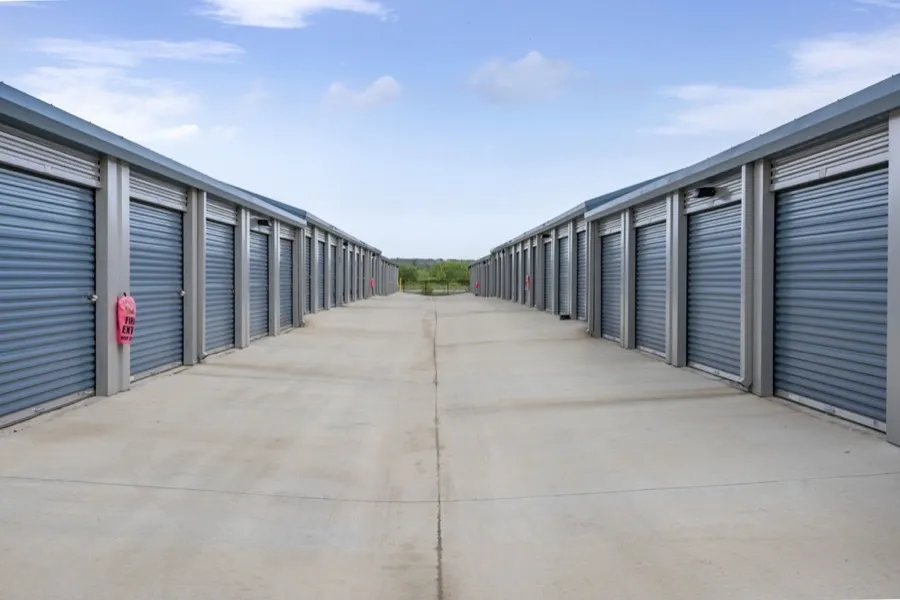 Outside of drive up self storage units with blue doors.