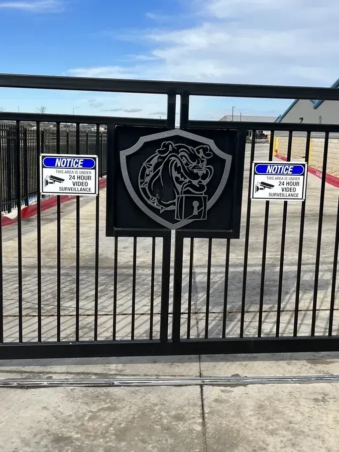 Gated entrance with the Guard Dog Storage logo.