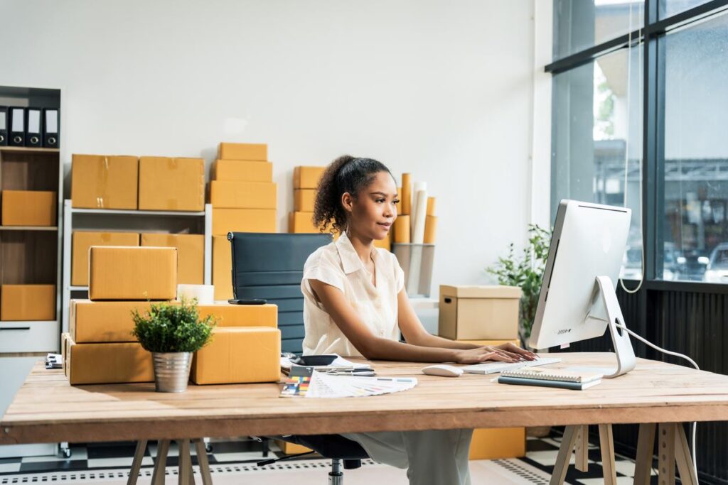girl by a desk with storage boxes around the room.
